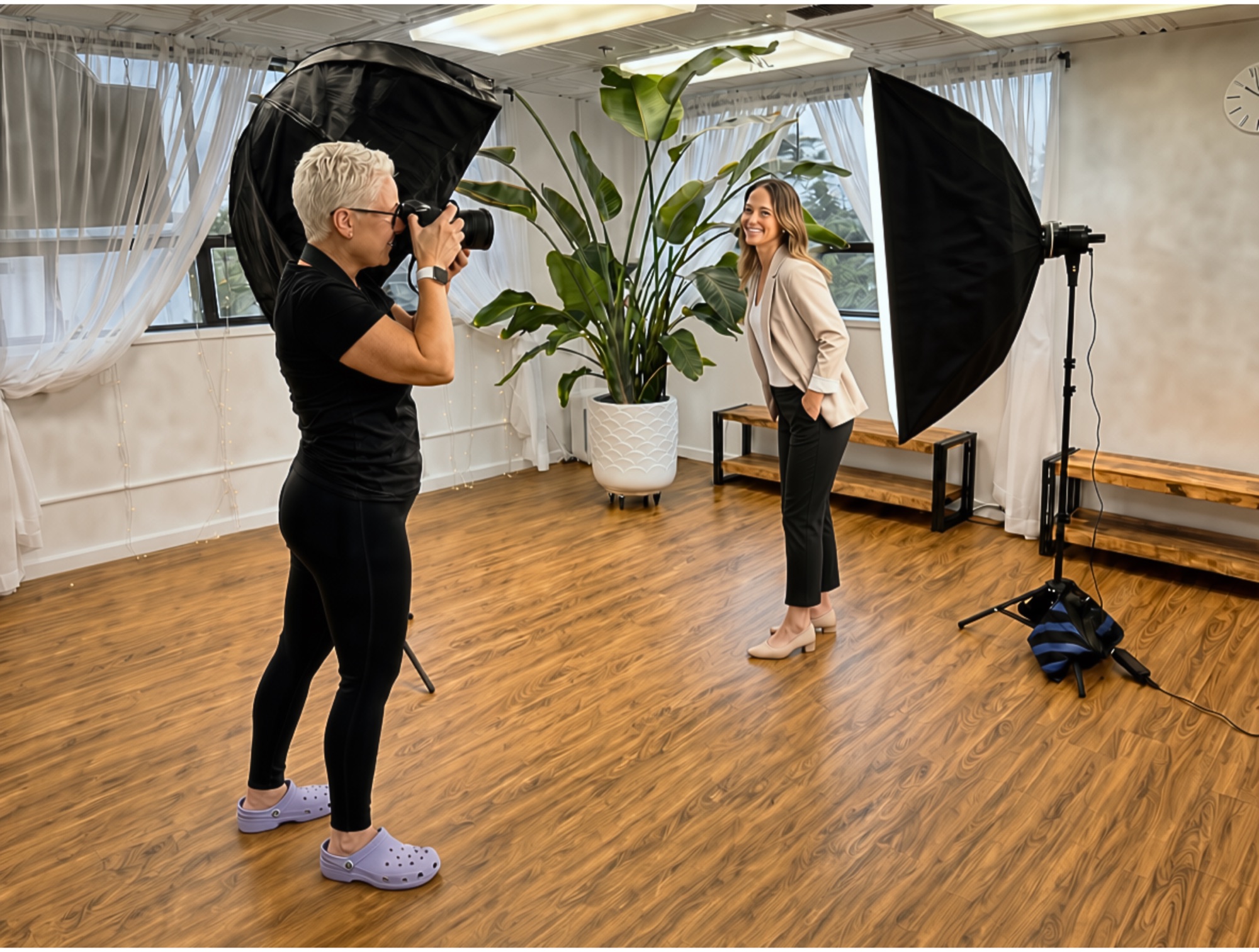 Molly photographs a business professional during an on-site headshot session with portable lighting in a bright studio space.
